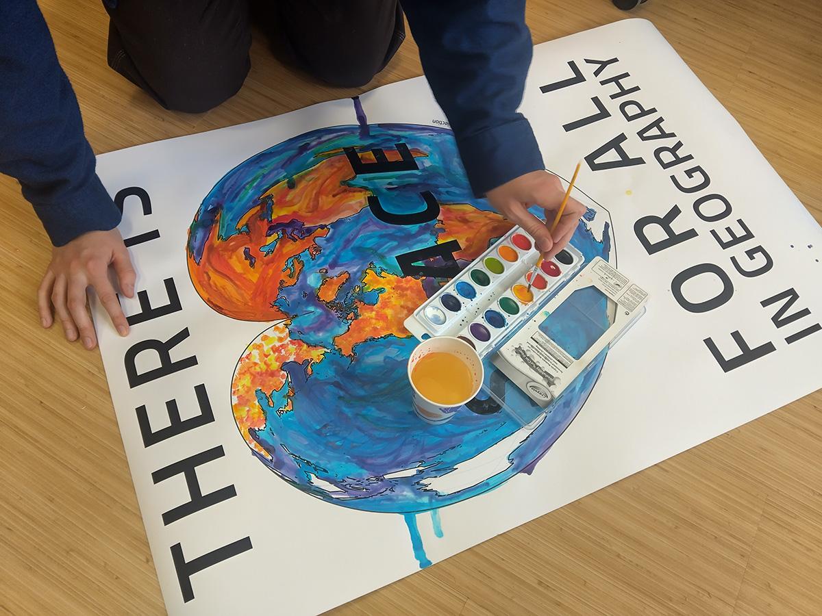 Lily playing with watercolors on a large printed map